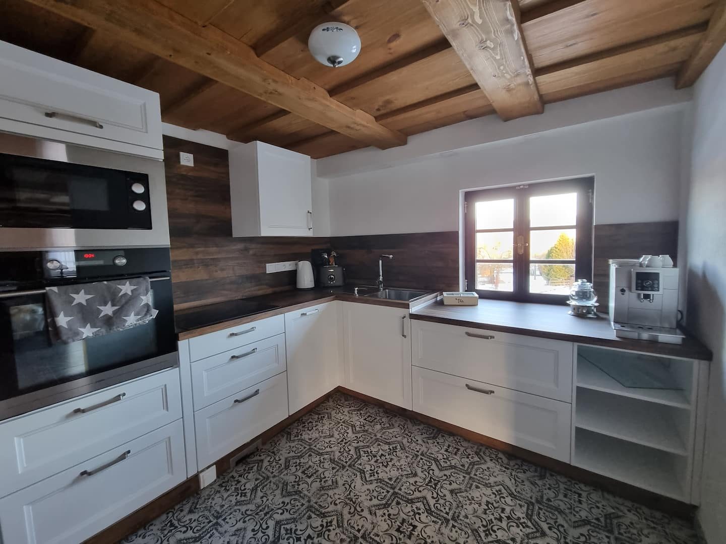 Bílá kuchyňská linka pod trámy